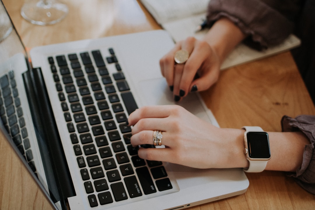 Person using MacBook writing content representing high-traffic blog management
