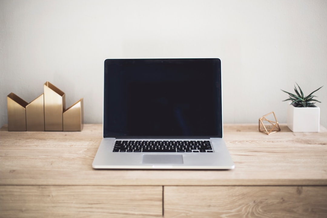 MacBook Pro on wooden table representing hosting setup for high-traffic bloggers