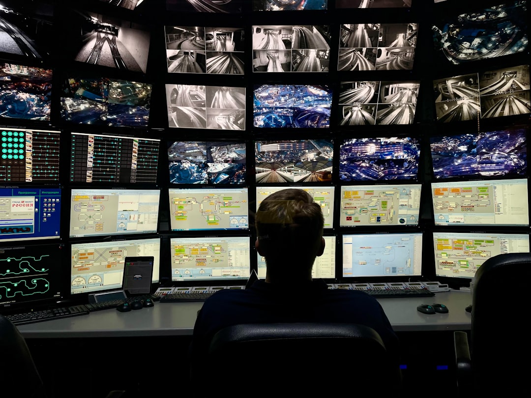 Man monitoring multiple screens representing DDoS attack detection and mitigation