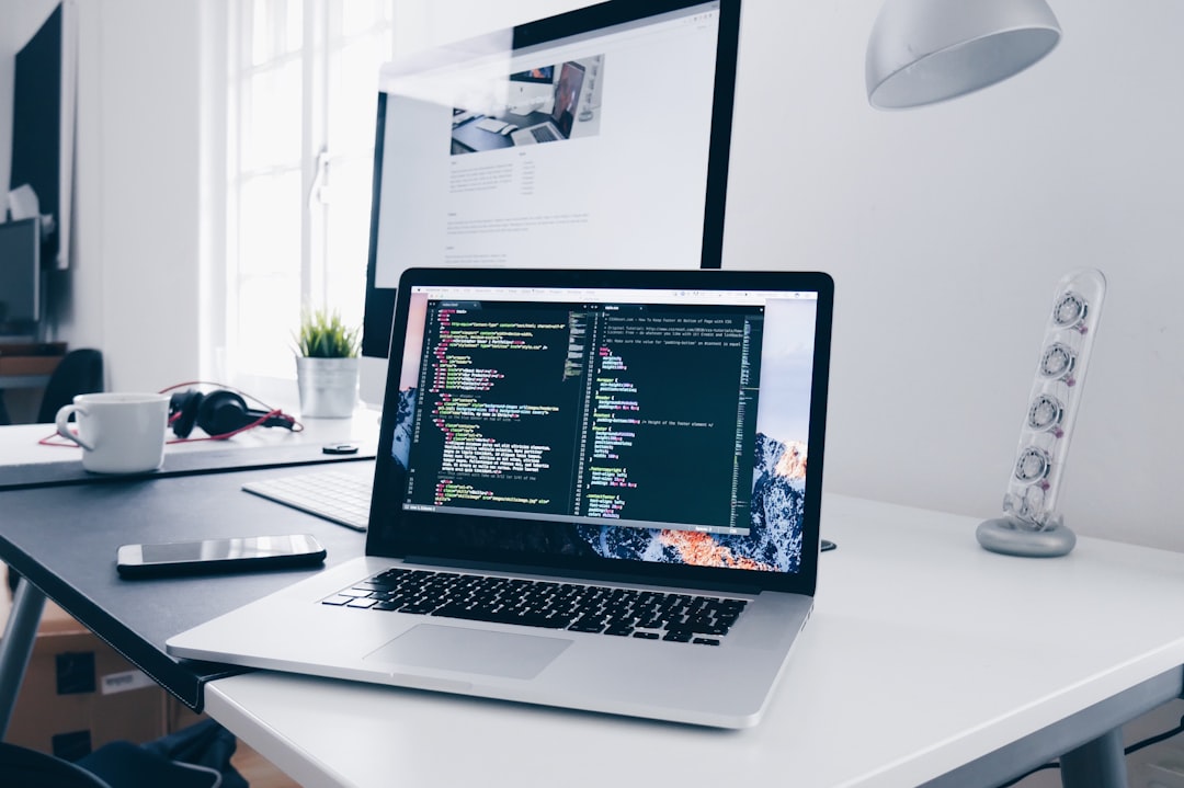 Developer writing code on multiple monitors representing web development workflow