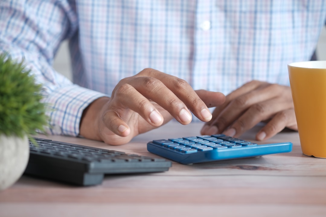 Person using calculator at desk representing hosting cost planning