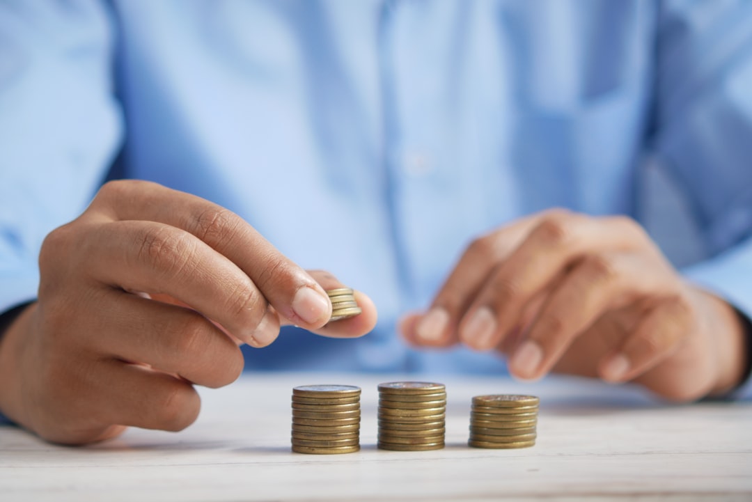 Person stacking coins representing comparing free, cheap, and paid hosting costs