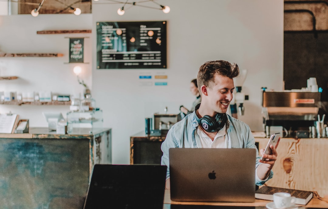 Man using smartphone smiling representing reseller hosting business owner